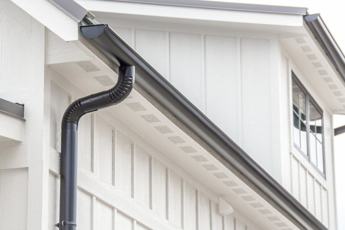 Sleek Black Gutter System with Downspout on a Modern White House